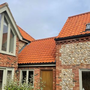 Old farmhouse with clean red roof tiles