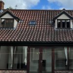 Old discoloured & dirty red roof tiles dormer bungalow